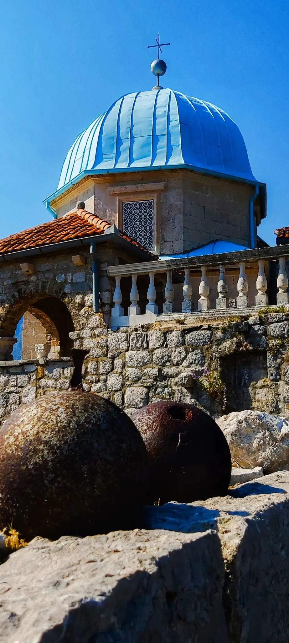 Old cannonballs beneath the blue dome of Our Lady of the Rocks, Perast