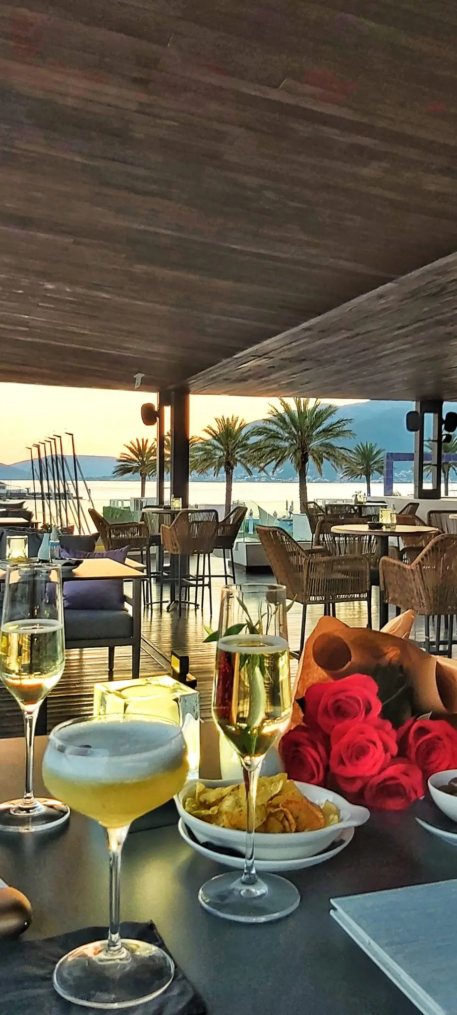 Glasses of champagne and red roses on a seaside terrace in Montenegro