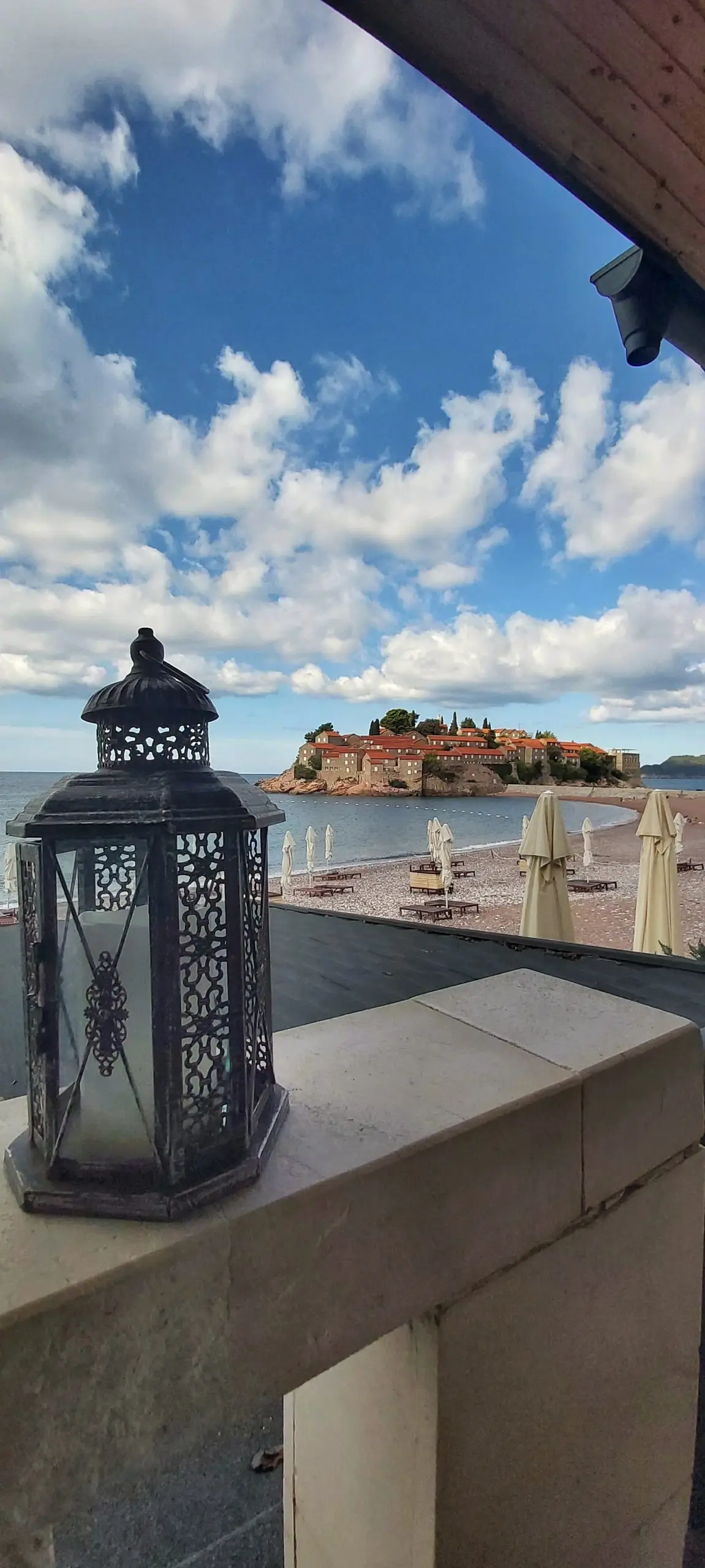 View of Sveti Stefan island from a seaside terrace with a lantern, Budva Riviera, Montenegro