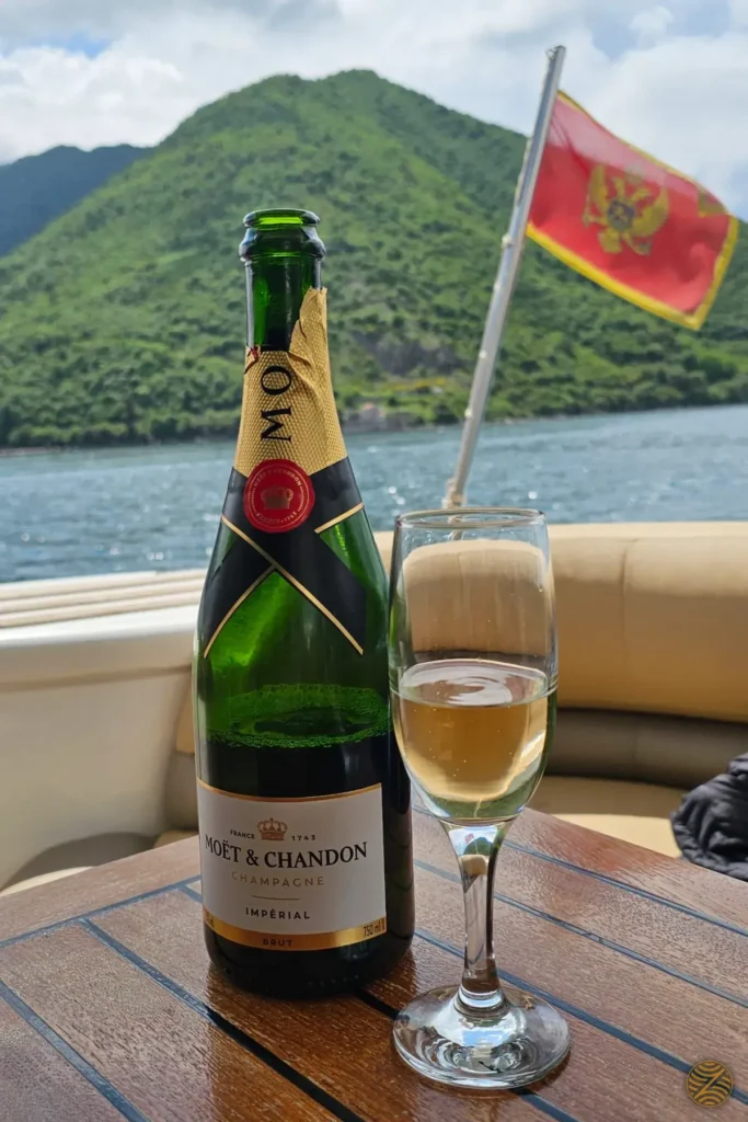 Champagne served on a private boat in the Bay of Kotor, with the Montenegrin flag behind
