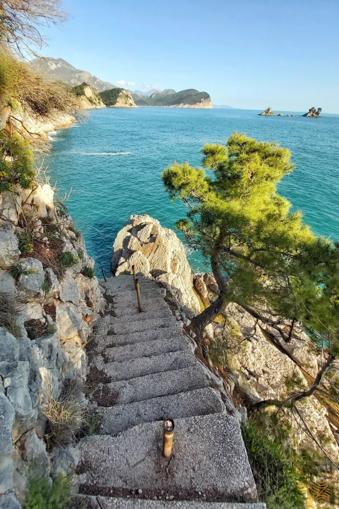 Stone steps down to the sea on the coastal path near Petrovac, with the islets of Katič and Sveta Nedjelja offshore