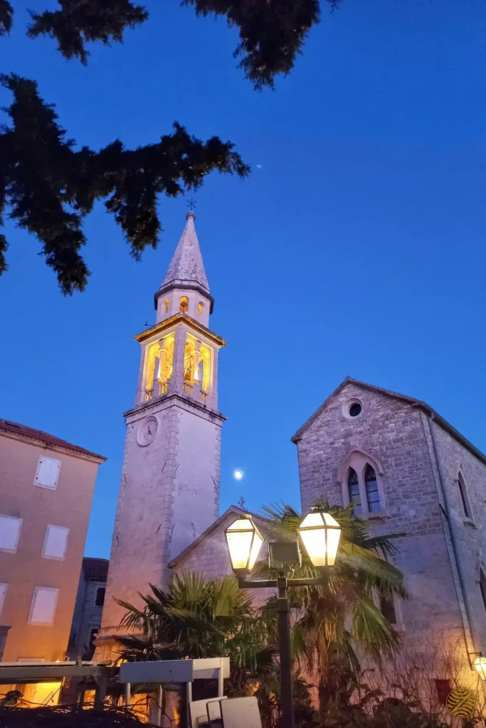 The bell tower of St John's Church lit at dusk in Budva Old Town